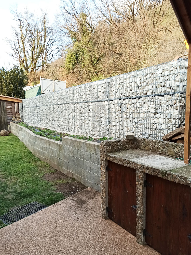 Muro de contenção estrutural em gabiões de alta resistência, utilizado para estabilização de terrenos e proteção de áreas exteriores.
