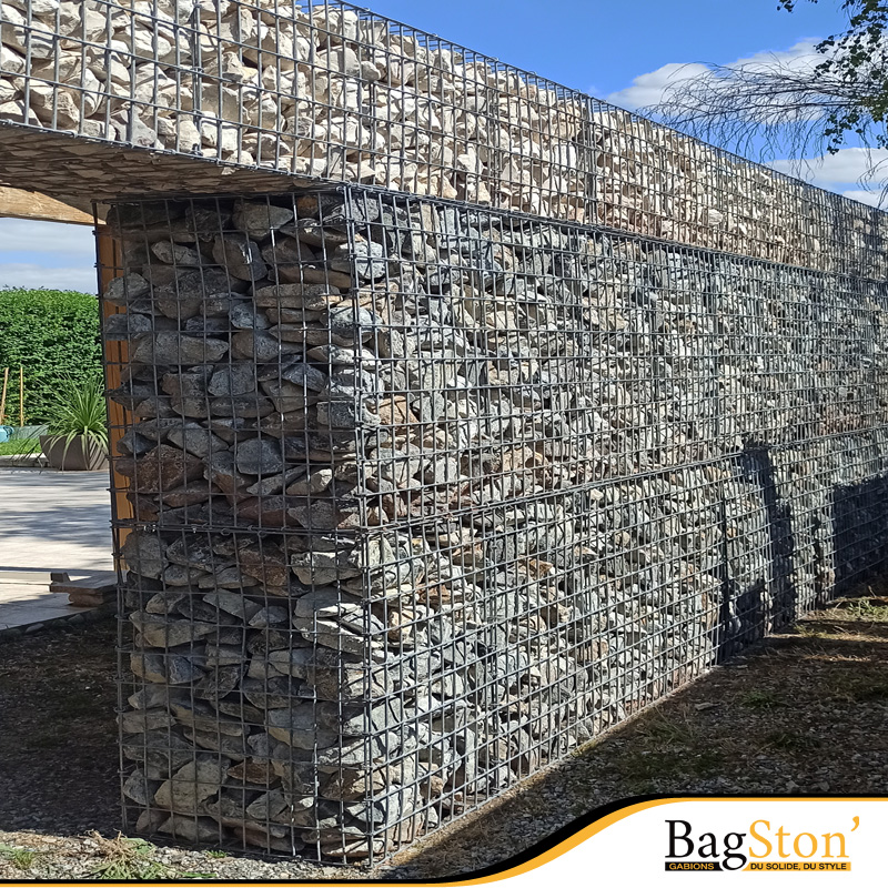 Estrutura de muro em gabiões Bagston, uma solução robusta e moderna para contenção ou decoração de espaços exteriores, preenchida com pedra decorativa de alta qualidade.